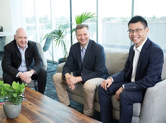 Our team members Michael, Brett and Dave sitting on a sofa in our office