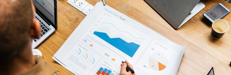 Man pointing to Business Intelligence report on table